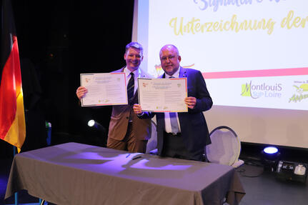 Bürgermeister Viktor Lorenz und Bürgermeister Vincent Morette beim Unterzeichnen der Partnerschaftsurkunde